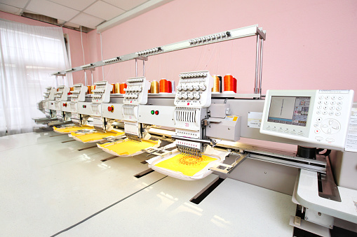 High technology automatic sewing machine control by computer programming. Sewing machine for mass production manufacturing industrial factory.
