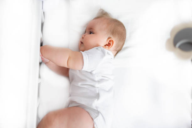 istock A calm baby is resting in a bed. 1416259946