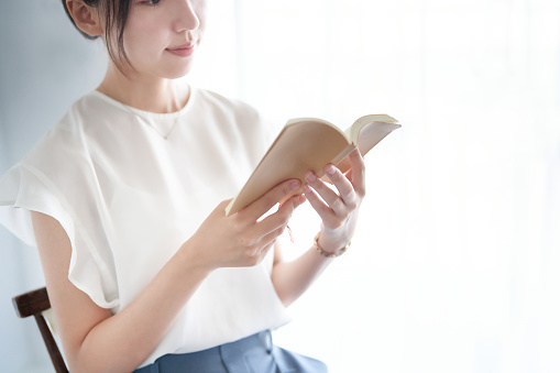 young woman reading a book indoors