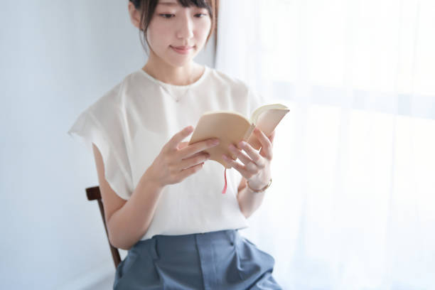istock woman reading a book indoors 1416267773