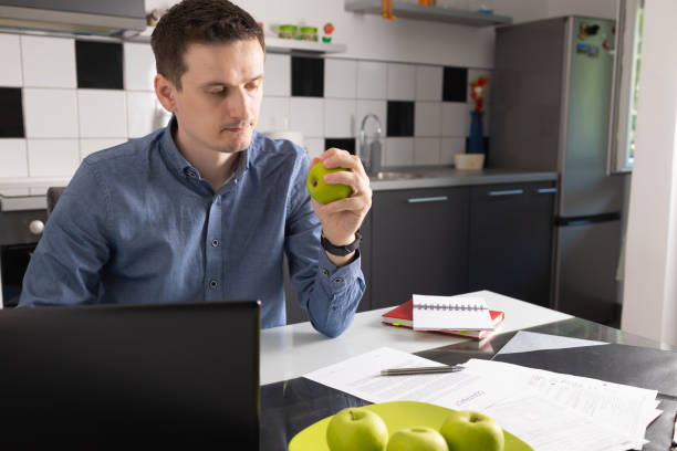 istock Man sitting at kitchen desk and having a lunch break. 1416268856