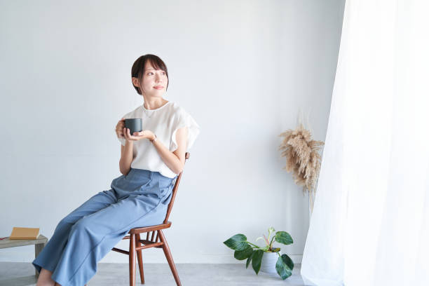 シンプルな空間でくつろぐ女性 - sitting ストック�フォトと画像