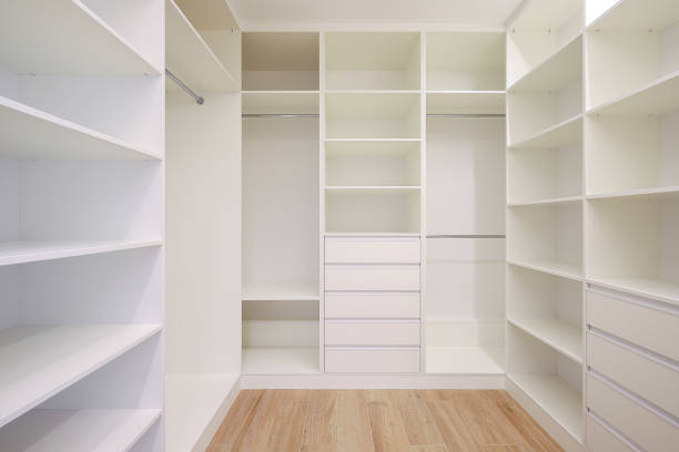 White wardrobe with shelves in the dressing room in a modern interior