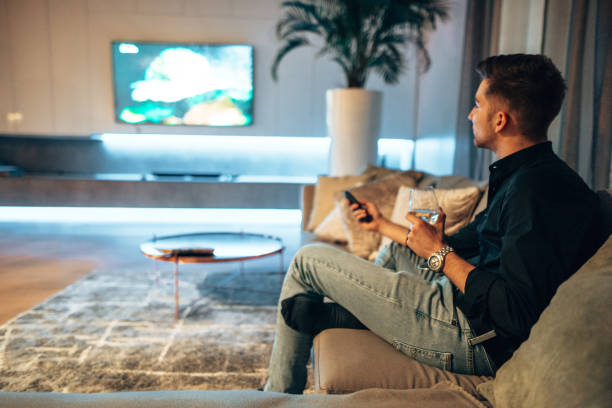 istock man working on the couch and watching tv 1416320570