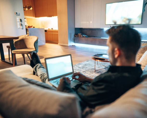 istock man working on the couch and watching tv 1416321128