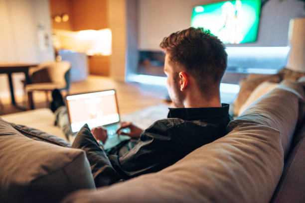 istock man working on the couch and watching tv 1416324424