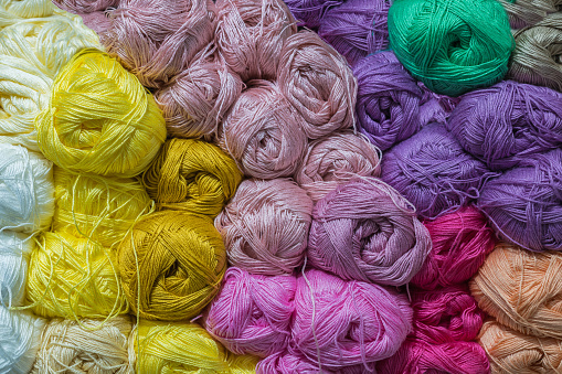 Bright multicolored balls of wool yarn for knitting. The concept of needlework and knitting.