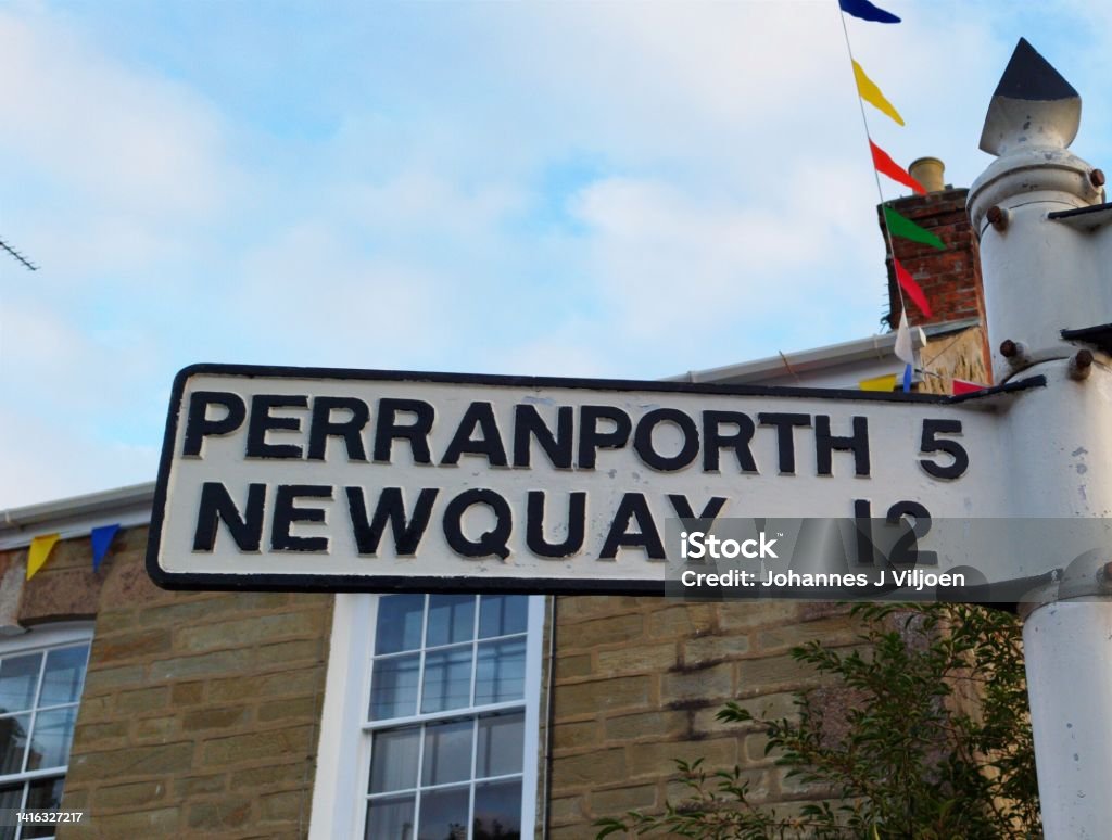 Signage for direction and distance to Perranporth and Newquay Vintage white metal sign in St Agnes, Cornwall showing the direction and distance in miles to Perranporth and Newquay Arrow Symbol Stock Photo