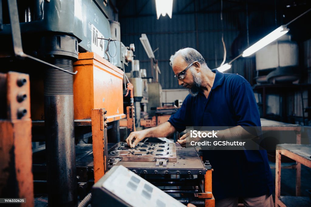 Industrial Machinery Operator Industrial machinery operator focused on completing routine tasks Manufacturing Stock Photo