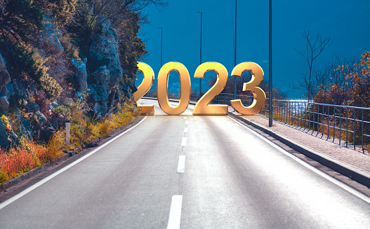 2023 New Year road trip and future vision concept. 2023 with highway road leading forward to happy new year celebration in beginning of 2023 for successful start
