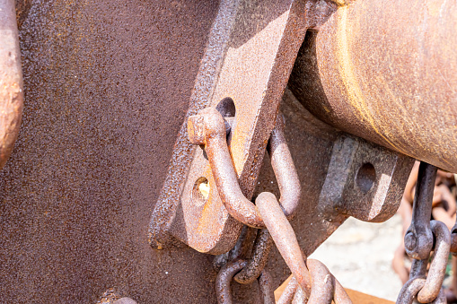 Close-up of a rusty chain connected to a metal construction on a shipyard. With copy space. Shot with a 35-mm full-frame 61MP Sony A7R IV.