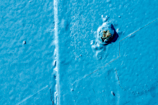 Close-up of rusty blue metal plate with rust spot on a shipyard. With copy space. Shot with a 35-mm full-frame 61MP Sony A7R IV.