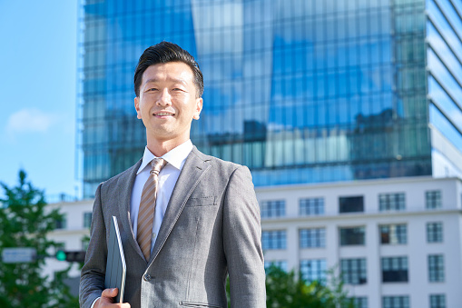 middle businessman standing in office district on fine day