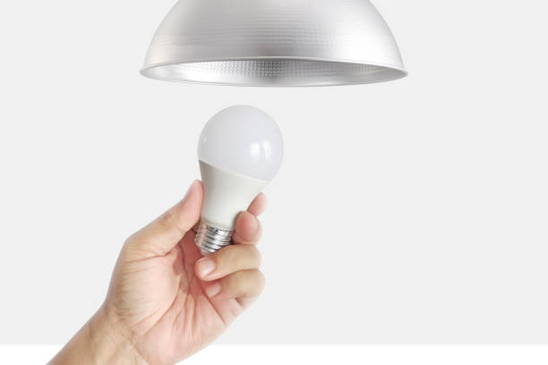 close-up da mão para trocar lâmpadas led - led lighting equipment light bulb installing - fotografias e filmes do acervo