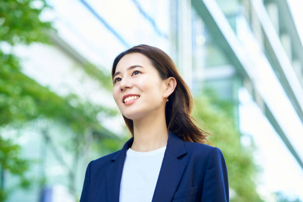 smiley business woman standing outdoors smiley business woman standing outdoors on fine day japanese ethnicity stock pictures, royalty-free photos & images