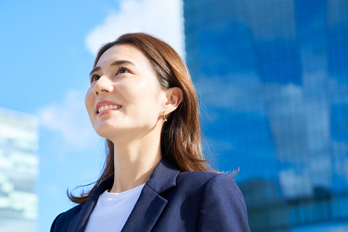 business woman standing in office district on fine day
