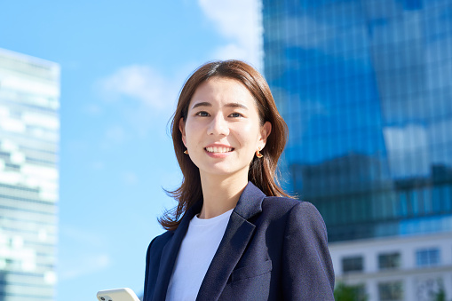 business woman standing in office district on fine day