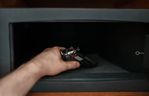 istock Man puts the weapon in the safe. 1416399952