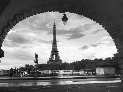 Black and white shot with a view of the Eiffel Tower, framed by the wall arch of the Passy metro viaduct of the Pont de Bir-Hakeim bridge. 06/05/2022 - Pont de Bir-Hakeim, 75015 Paris, France