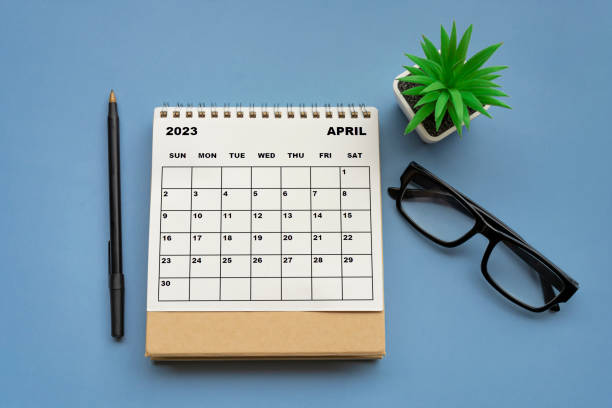istock April 2023 desk calendar on blue background. Directly above. 1416412368