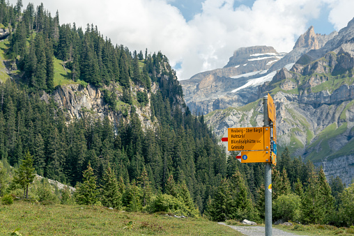 Signposts pointing to the various hiking and mountain hiking trails on the Oeschinensee. The famous Oeschinensee lake which is located at 1500 meters above sea level and is located above Kandersteg in the Bernese Oberland. 09/04/2021 - Canton of Bern, Switzerland