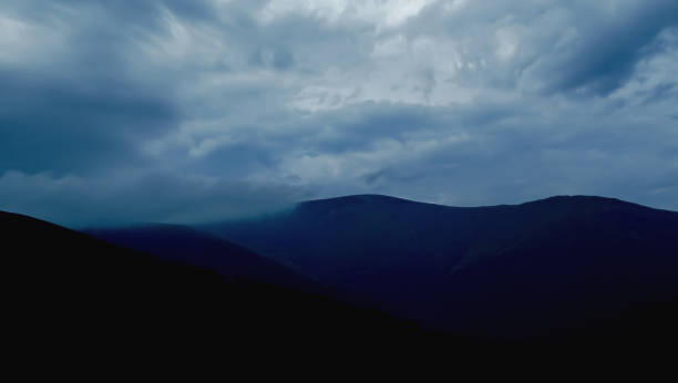 istock Dramatic sky in blue-gray tones over the mountains. Almost black mountains and blue-gray, cloudy skies. Stormy skies over the mountains. 1416415253