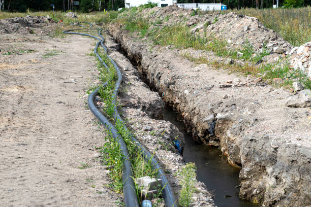 istock Plastic water pipe lying along the ditch with high groundwater, water connection in the housing estate. 1416415307