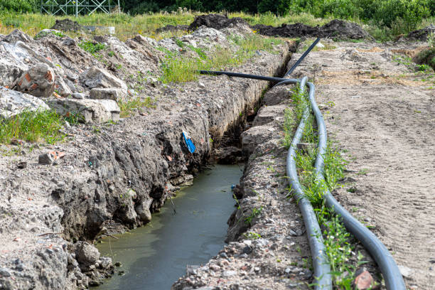 istock Plastic water pipe lying along the ditch with high groundwater, water connection in the housing estate. 1416415340