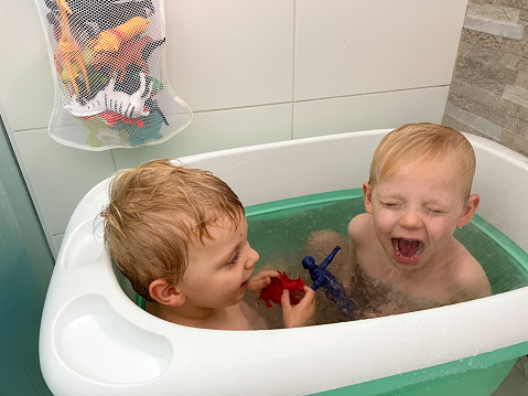 Siblings having fun in the bathtub, photo taken on smartphone