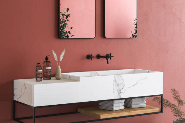 Close up of white marble basin with two mirrors hanging in on red wall, minimal cabinet with black faucet in minimalist bathroom. Front view. 3d rendering stock photo