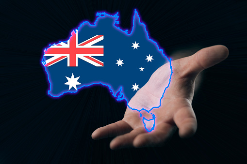 helping hand of australia, map of australia in hand on dark background