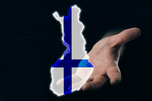 helping hand of Finland, map of Finland in hand on a dark background