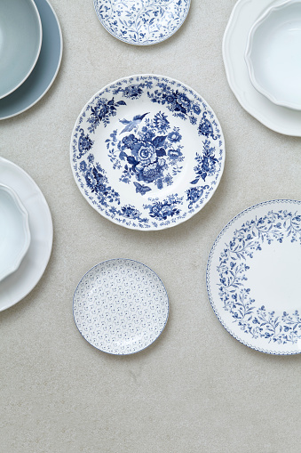 Variety of domestic porcelain plates on a modern marble kitchen table, top view with a copy space