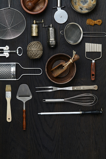 Variety of kitchen utensils on a rustic wooden table, top view with a copy space