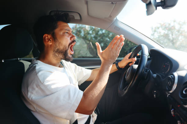 Young man getting angry on the road Angry screaming male driver driving car. Driving training and fear of traffic car traffic concept furious stock pictures, royalty-free photos & images