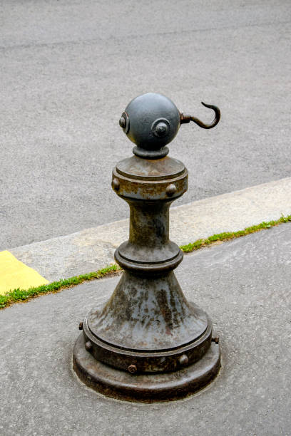 istock Old metal bounding column with a hook is installed on the sidewalk near an asphalt road. 1416439297