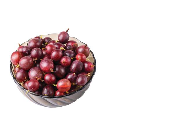 Macro view of bowl with ripe gooseberries on white background isolated.