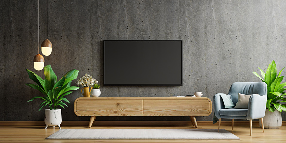 TV LED on the cabinet and armchair in loft style house on concrete wall background.3d rendering