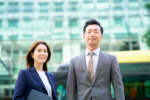 business man and woman in suits standing outdoors