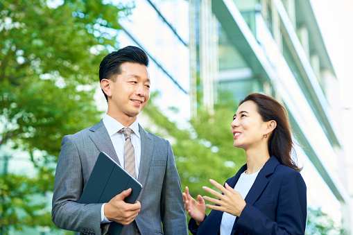 business man and woman in suits standing outdoors