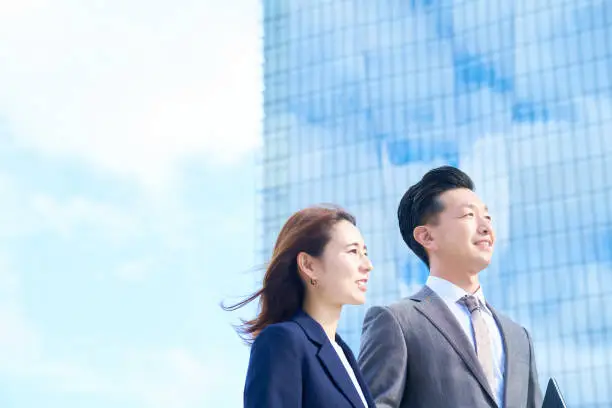 Photo of Business man and woman standing in front of skyscraper