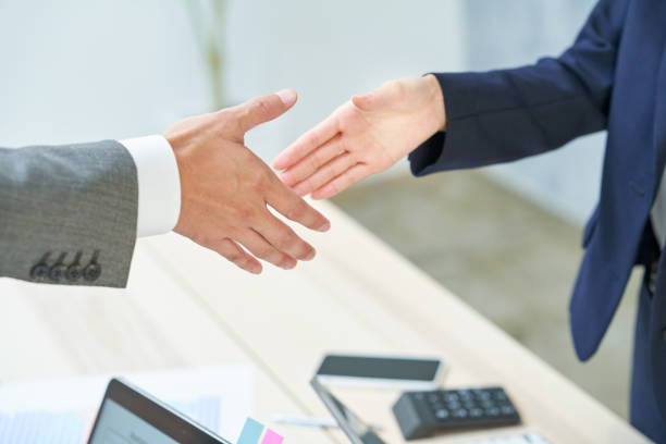 istock business man and woman shaking hands 1416447766