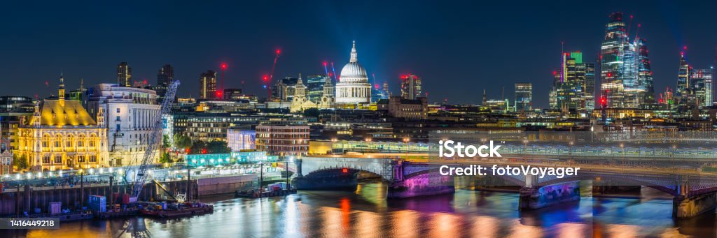 London night panorama over St Paul's Cathedral skyscrapers Thames Embankment Aerial panoramic view across the River Thames to St. Paul’s Cathedral and the glittering skyscrapers of the City of London illuminated at night. City Stock Photo