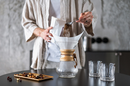 man prepare coffee in glass chemex at home kitchen