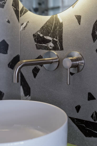 istock silver water tap on marble wall and white washbasin, closeup 1416451341
