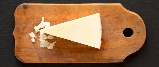 pecorino romano käse auf rustikalem holzbrett auf schwarzer oberfläche, draufsicht. flach gelegt, über kopf, von oben. - weichkäse stock-fotos und bilder
