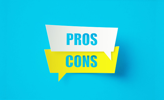 Pros and cons written cut out yellow and white speech bubbles sitting on blue background. Horizontal composition with copy space.
