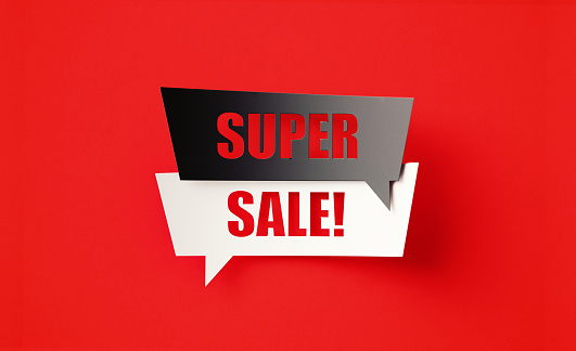 Super Sale written cut out black and white speech bubbles sitting on red background. Horizontal composition with copy space.