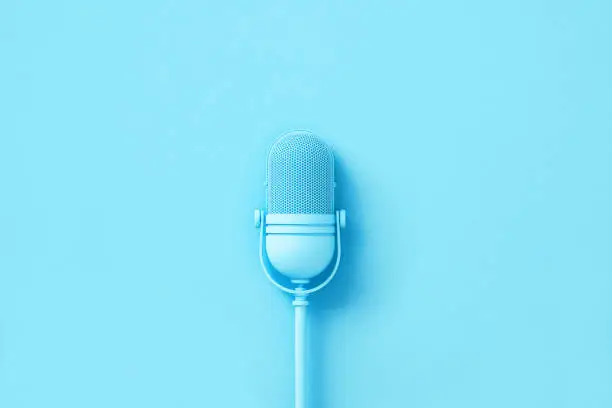 Blue microphone on blue background. Horizontal composition with copy space.