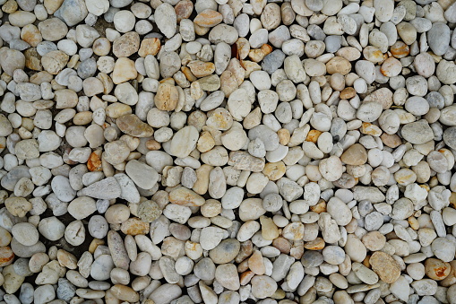 Natural background of small stones and pebbles on the ground with top view